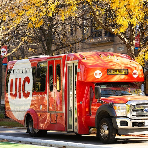 A UIC bus shuttle is driving on Harrison St.